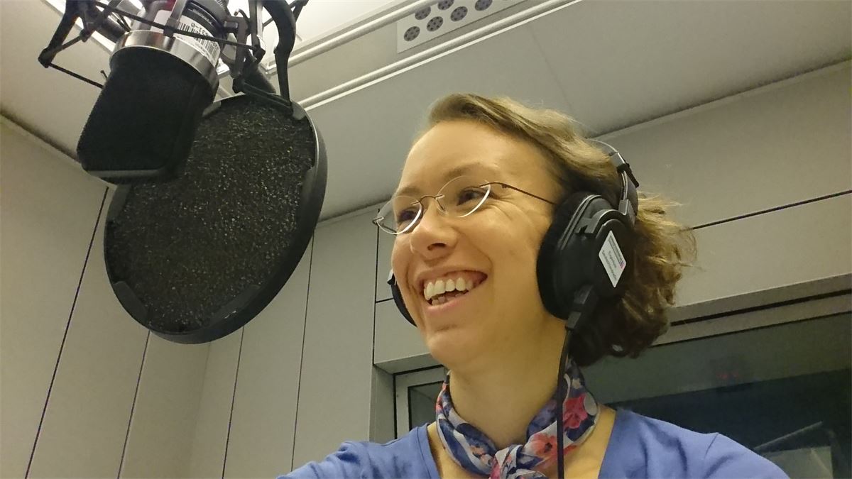 Daniela Gieseler mit Kopfhörern am Mikrofon bei einer Podcast-Aufnahme