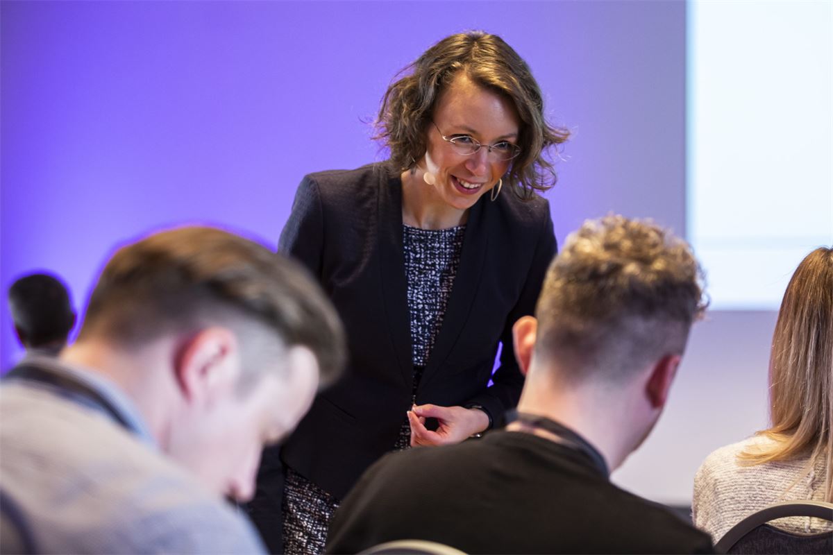 Daniela Gieseler im Gespräch mit Teilnehmenden eines Workshops